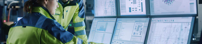 Project engineer talks to female operator who controls facility production line.