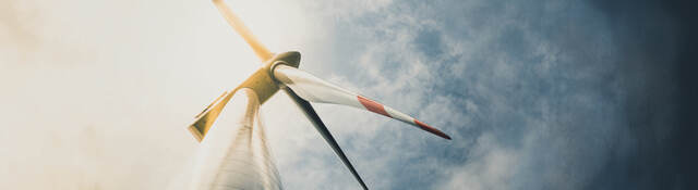 Looking up at a wind turbine