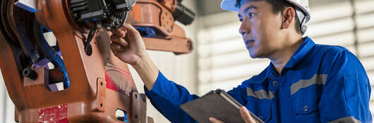 Senior Engineer testing of an industrial robot accuracy and repeatability in off and online by using digital tablet.