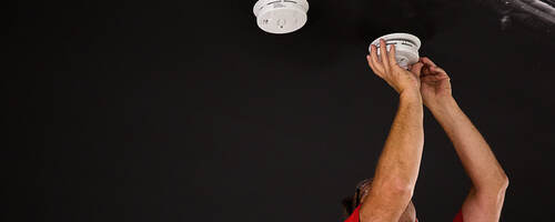 UL engineer installing smoke detectors for testing